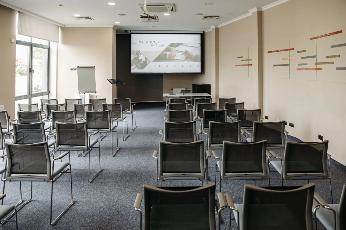 Sala vacía con pantalla de presentación; foto de apoyo, no demostración de Gemini.